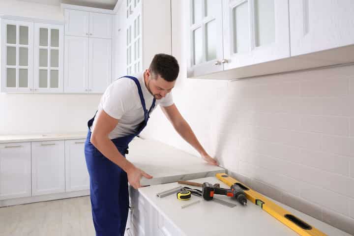 A kitchen remodeling expert installs countertops in a Pearland, TX home.